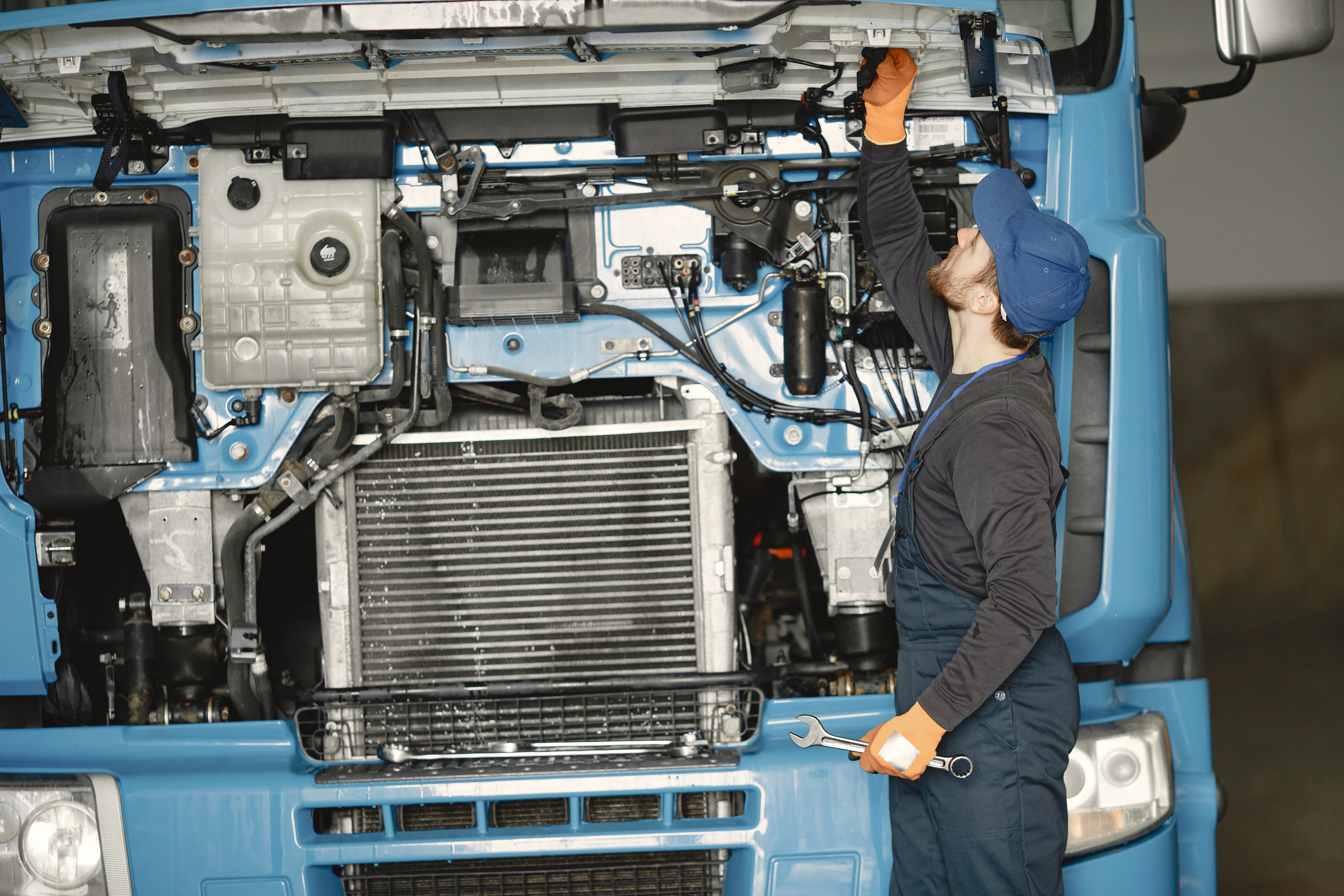 Technician performing preventative maintenance on a truck